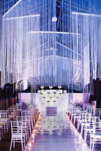 white chairs in wedding hall and wedding ceremony venue in white and violet and festoon shining